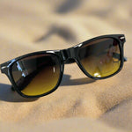 Black sunglasses with brown lenses on a white background