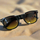Black sunglasses with brown lenses on a white background