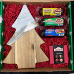 Box with Johnsonville sausages, a wooden cutting board, and a Christmas tree-shaped item on red crinkle paper.
